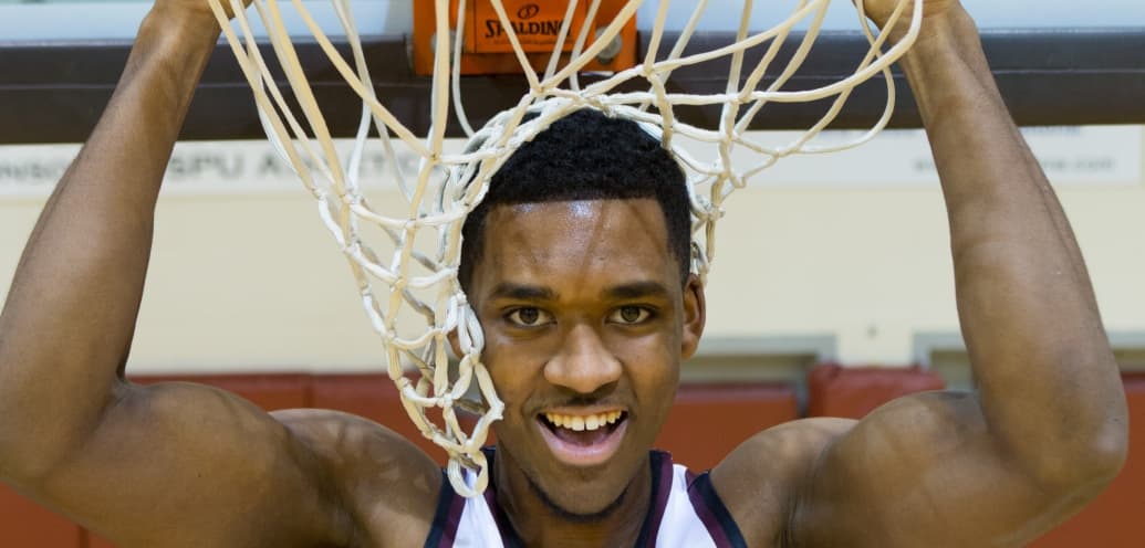 Kevin Johnson hanging from a basketball hoop