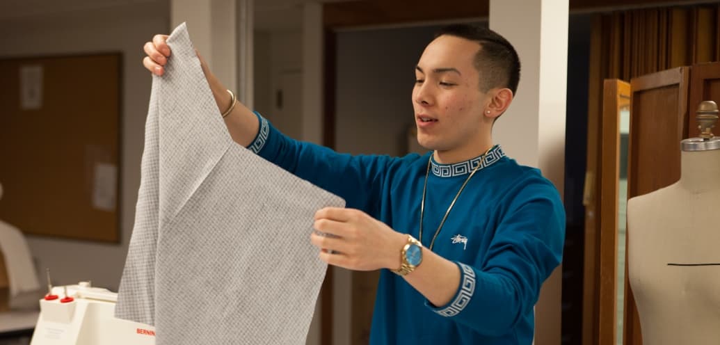 SPU Apparel Merchandising Major Nathan Samayo holding up a piece of fabric