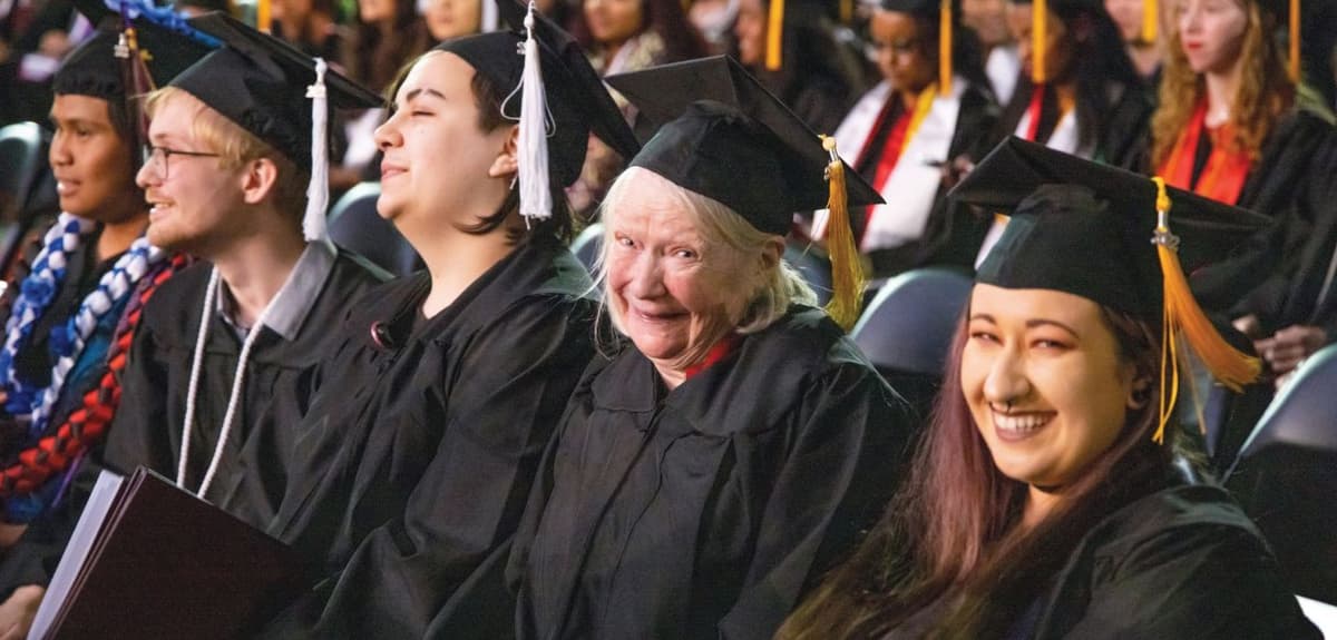 Yaant Best grins alongside fellow grads during the Commencement 2022 ceremony | photo by Mike Siegel