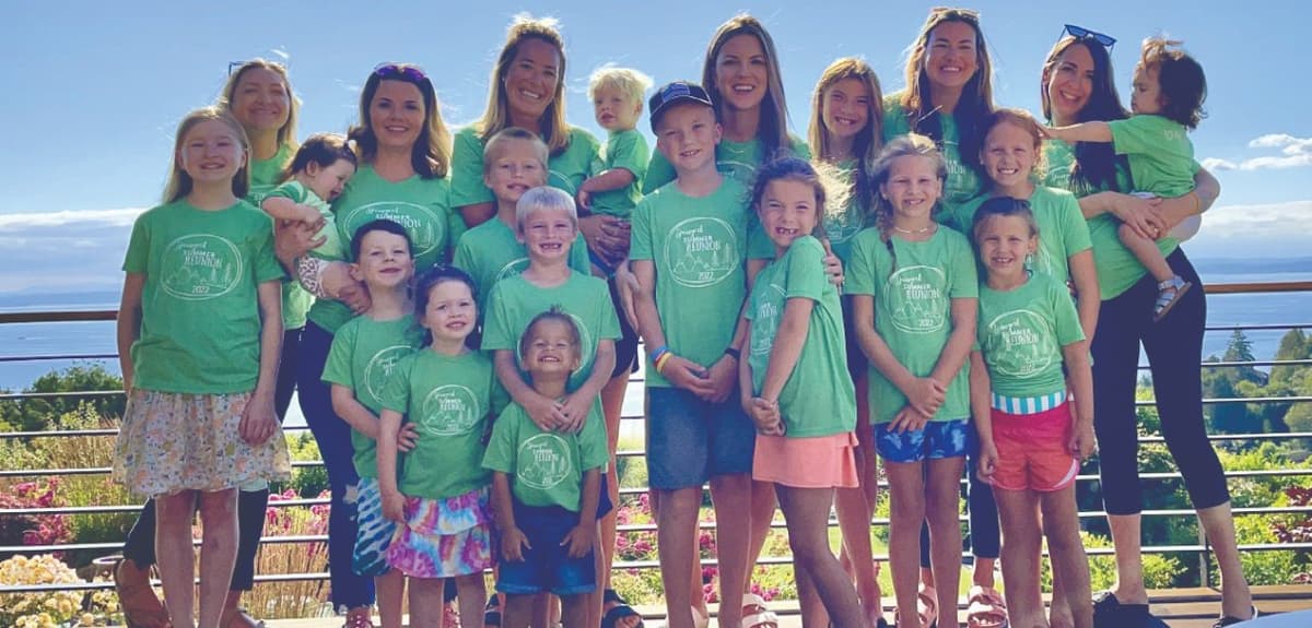 The SPU alums pose outside with their families, all in matching green t-shirts