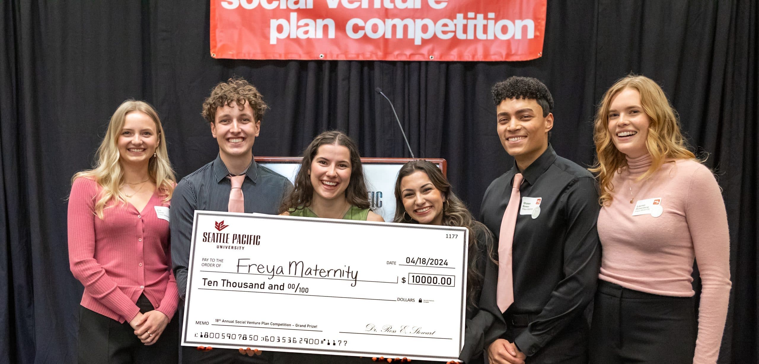 Grand prize winning students holding a large check showing $10,000 cash prize