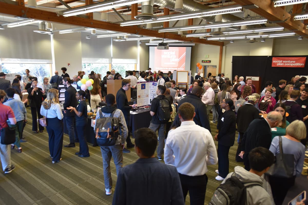 wide shot of Social Venture Plan Competition in April 2025. Crowds of people talking in small groups.