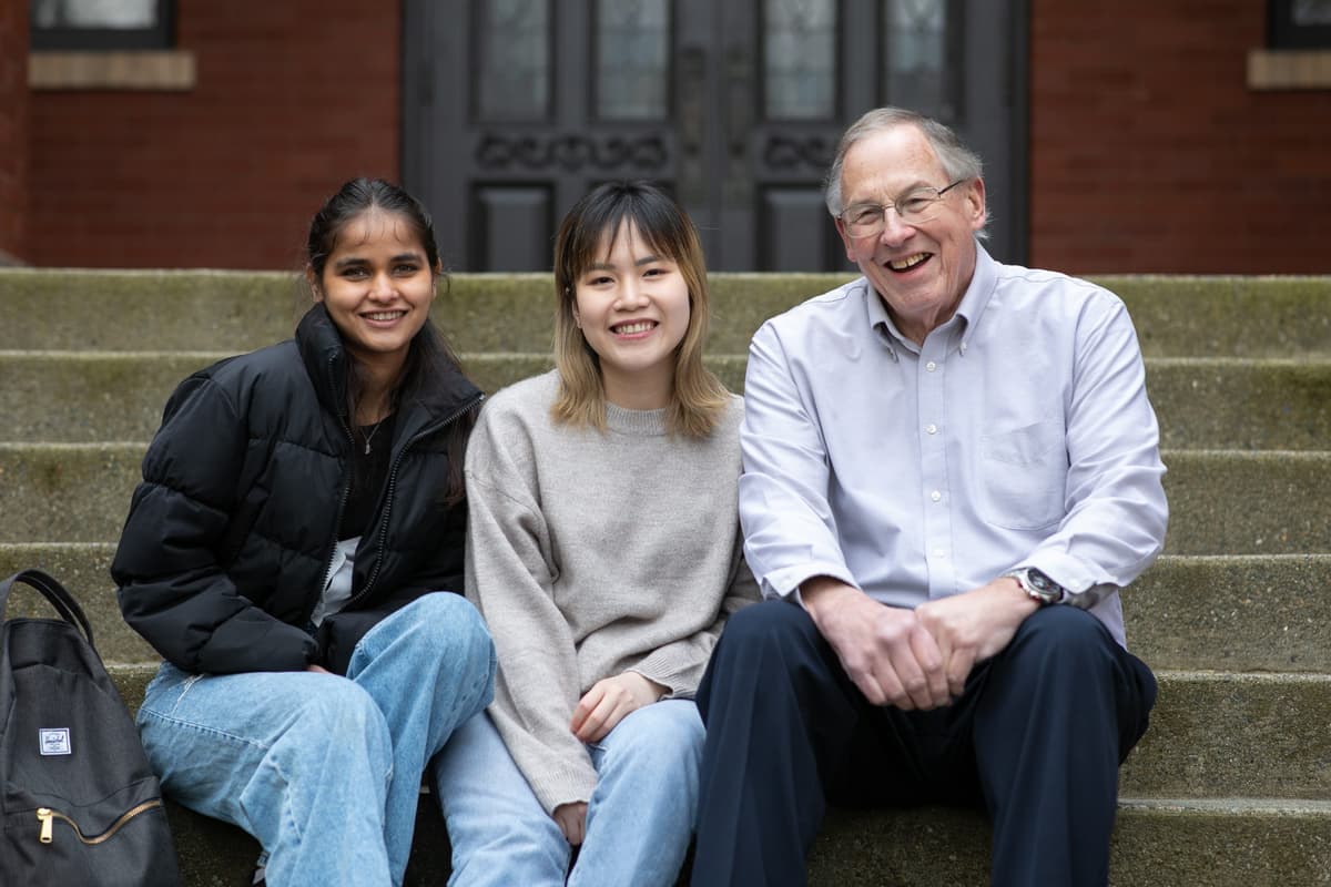 Alumnus Jay Morgensen and students sitting on steps.