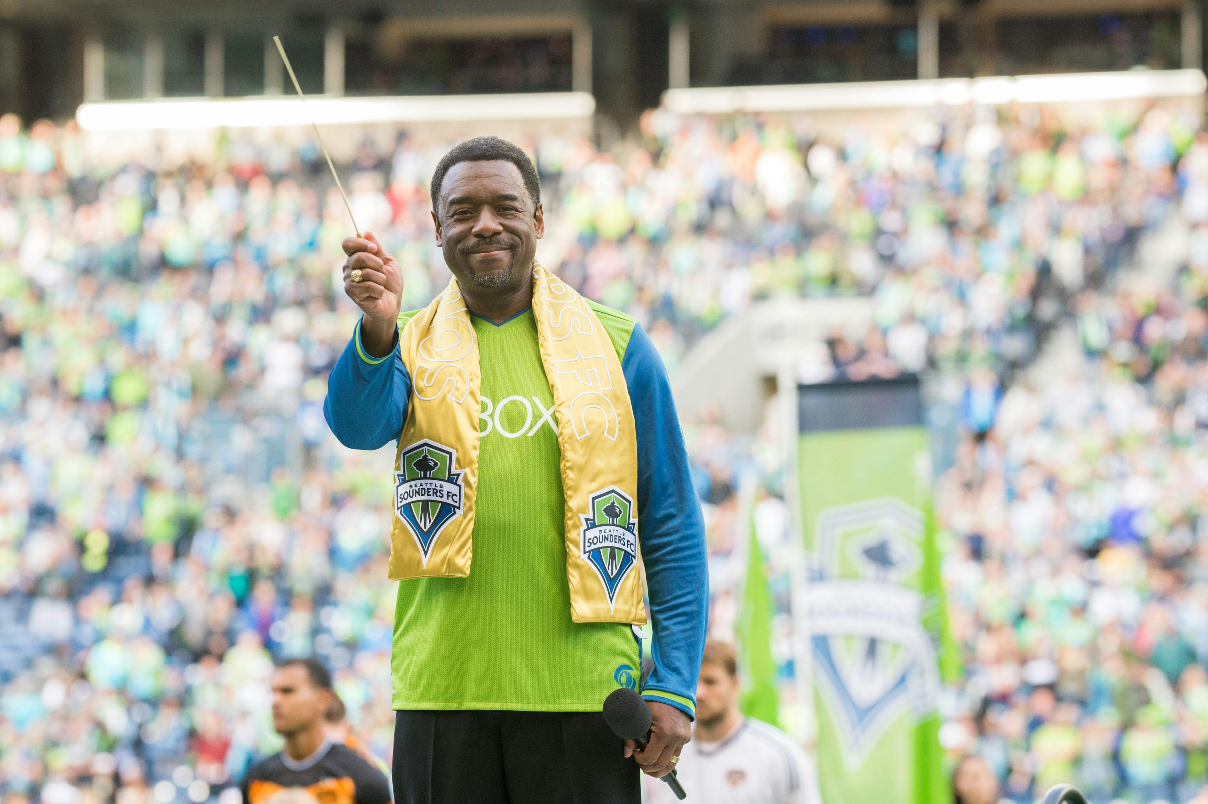 Stephen Newby conducts the National Anthem before a Seattle Sounders game wearing his Golden Scarf