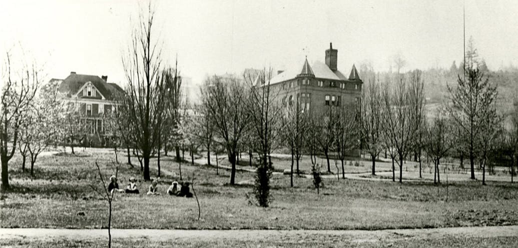 Alexander Hall in 1911, sitting across a field of young trees.