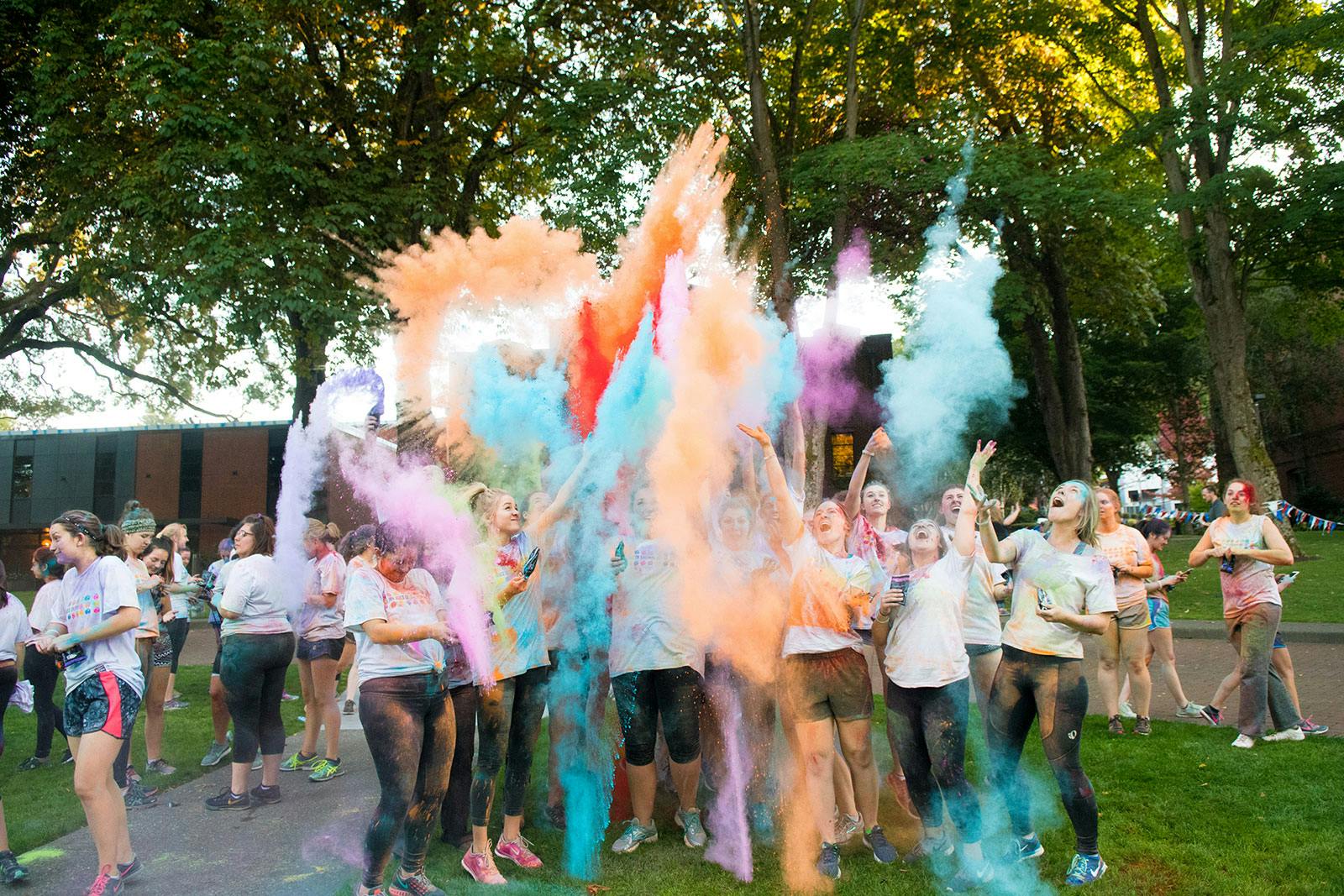 students throwing colored dust in the air