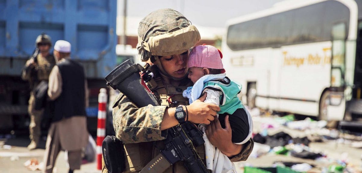A soldier comforts a small child
