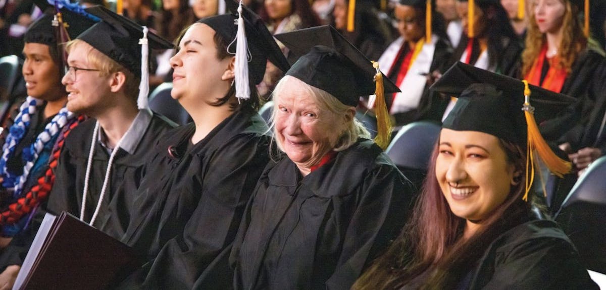 Yaant Best grins alongside fellow grads during the Commencement 2022 ceremony | photo by Mike Siegel