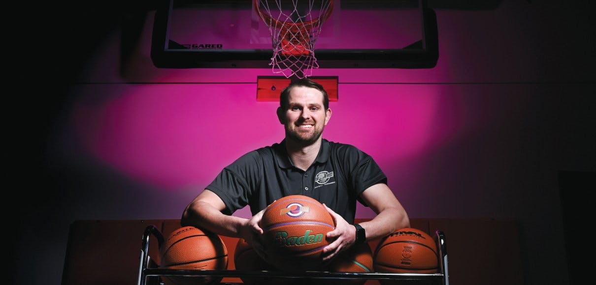 Riley Stockton poses against a pink-lit wall, holding basketballs | photo courtesy The Spokesman Review