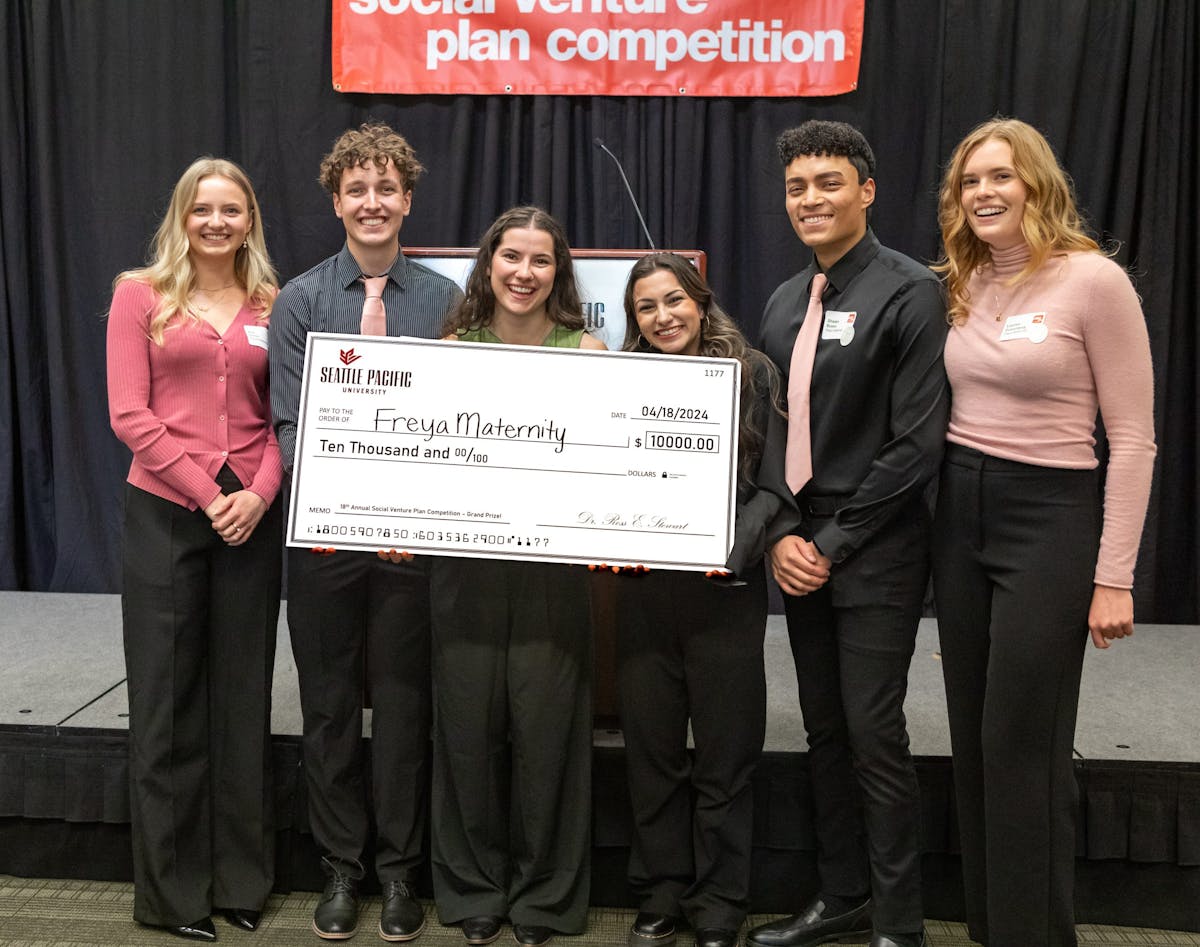 Grand prize winning students holding a large check showing $10,000 cash prize