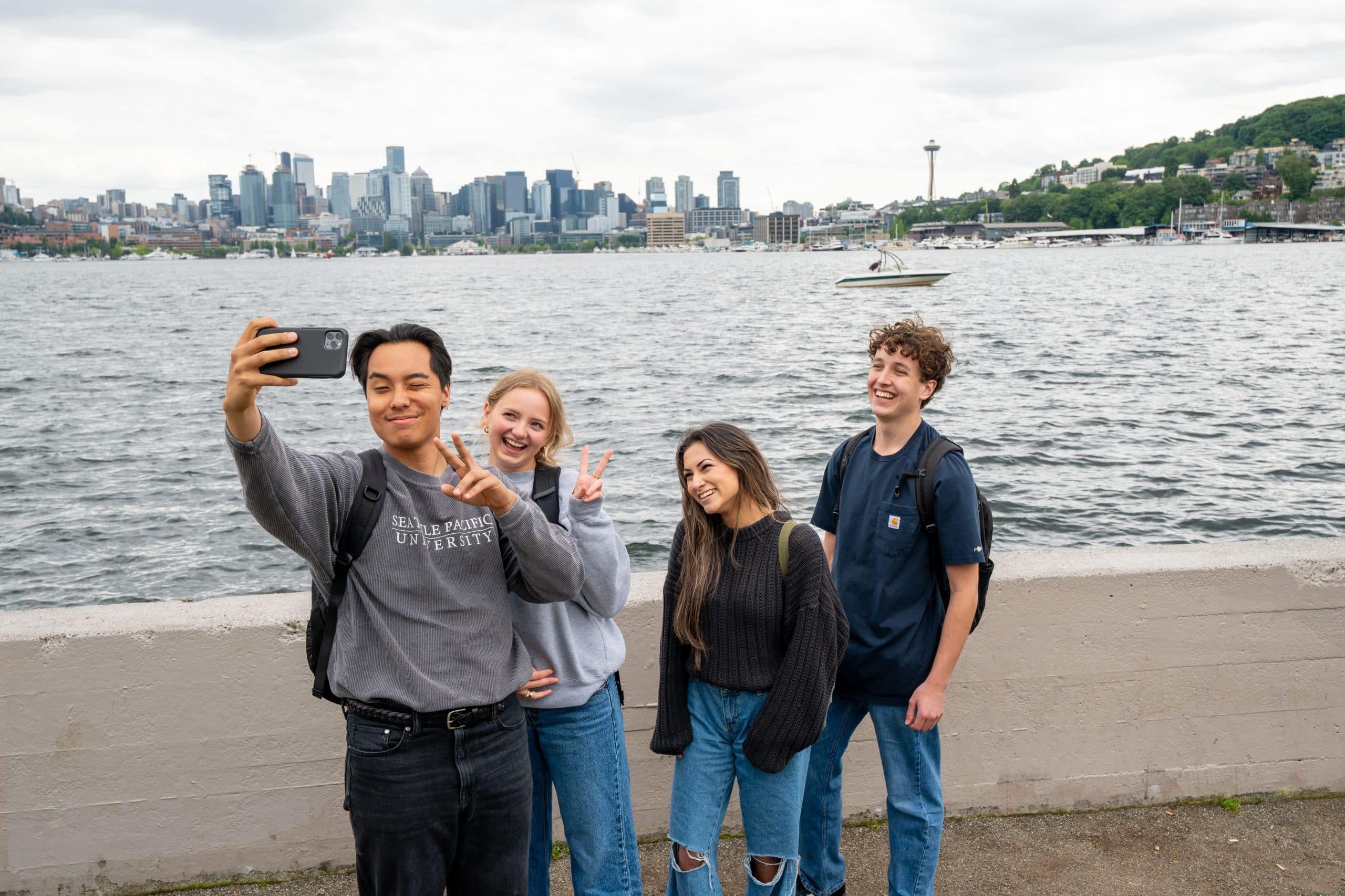 Students posing for a funny selfie with Lake Union and Seattle skyline in the background